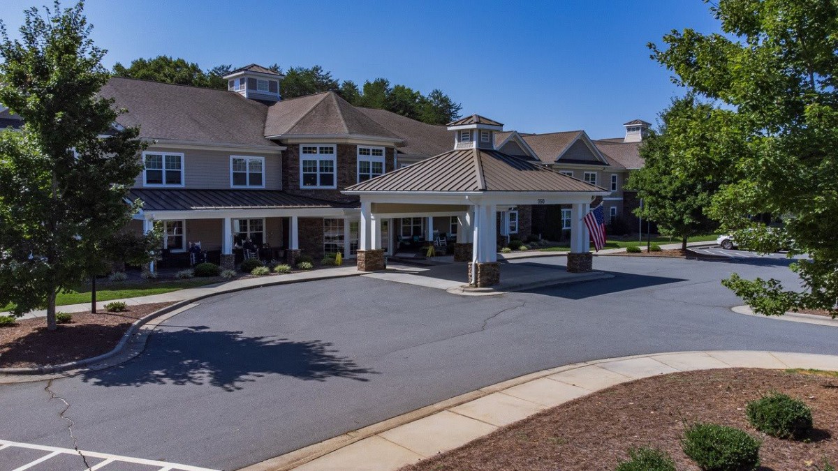 A suburban residential building with a covered entrance and landscaped surroundings.