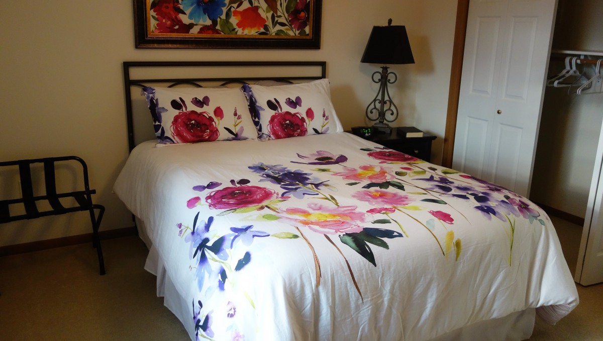 A cozy bedroom with floral bedding and stylish decor.