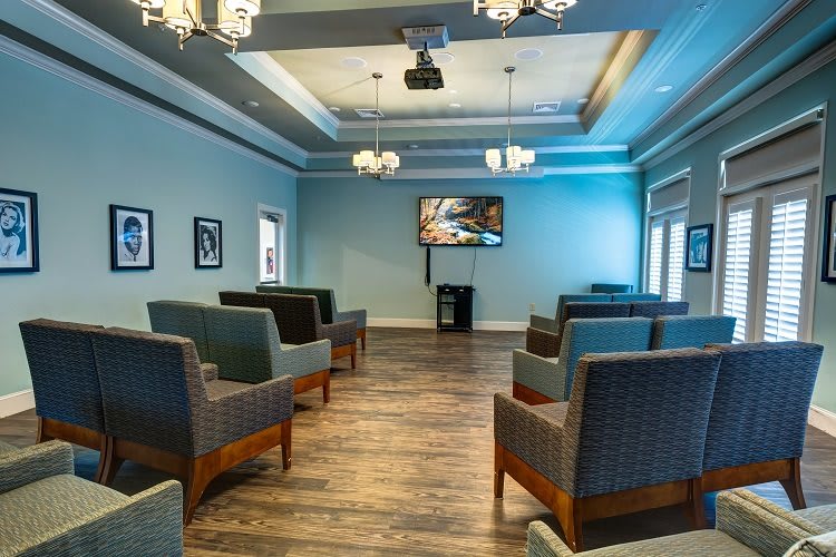 A modern waiting room with comfortable seating and a television.