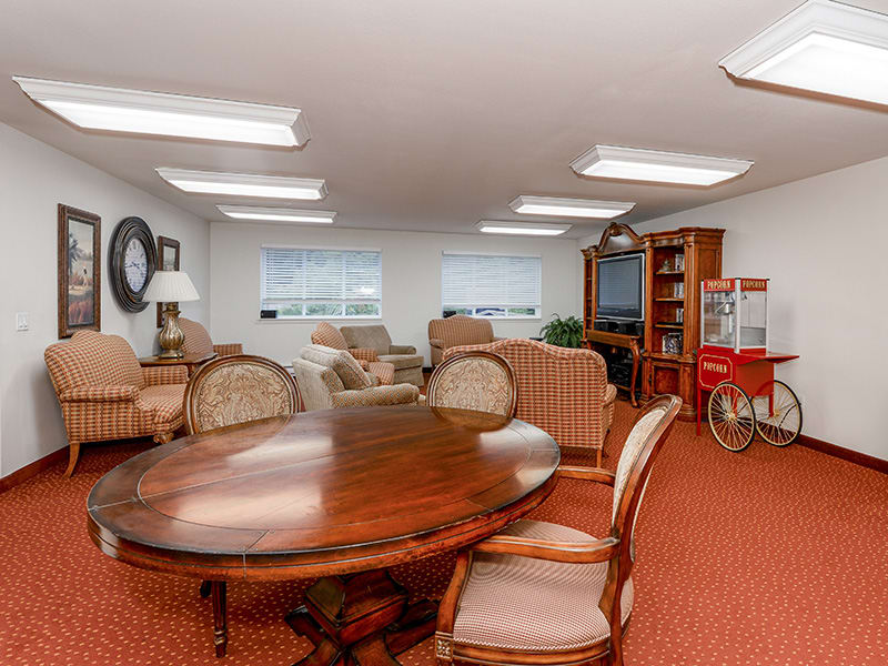 A cozy living room with comfortable seating, a large wooden table, and indoor lighting.