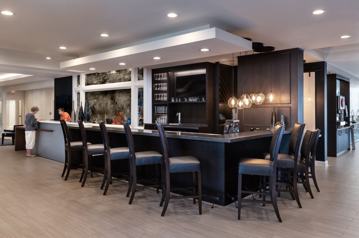 A modern bar with sleek lighting and comfortable seating.