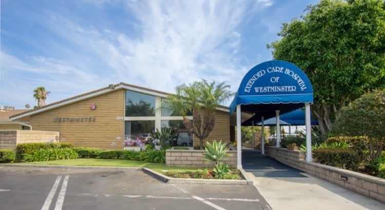 Exterior view of a building with an entrance awning labeled 'Skilled Care Center' and well-maintained landscaping.