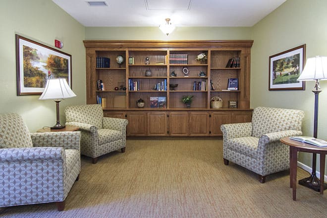 A cozy sitting area with armchairs and a bookshelf.