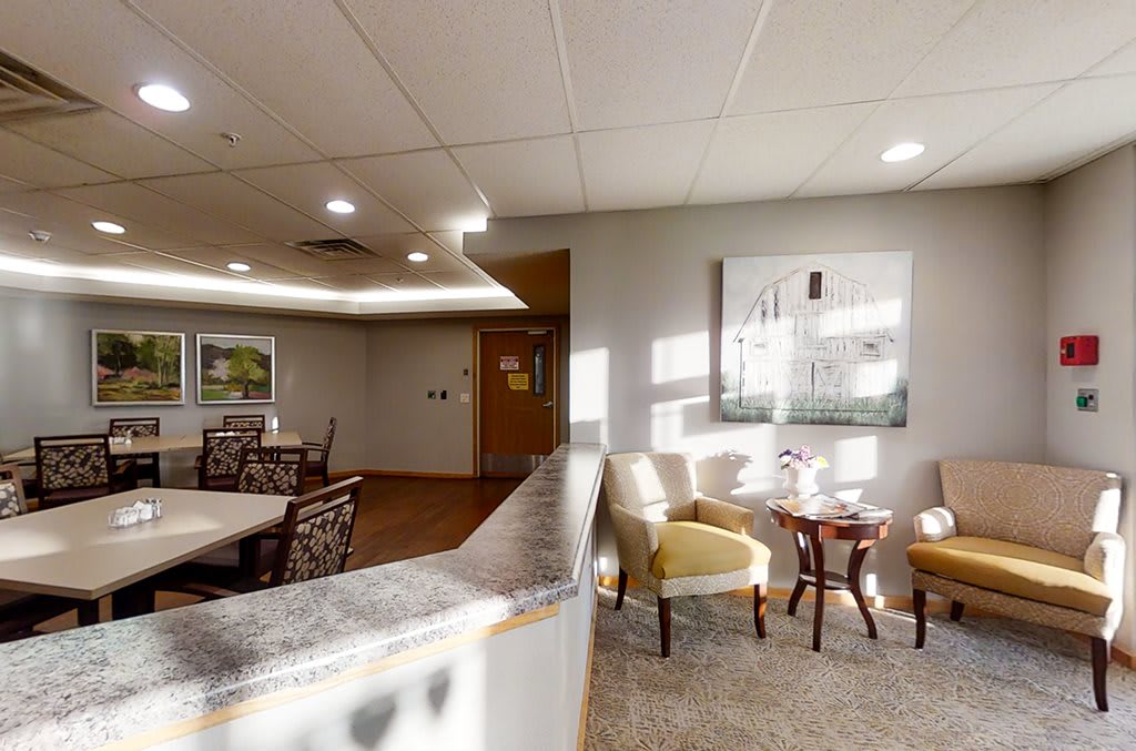 A well-lit waiting area in an office with comfortable chairs and decorative artwork.