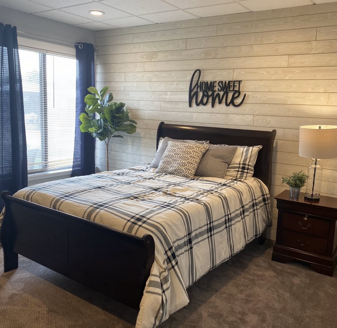 A cozy bedroom with a plaid-patterned bedspread and stylish decor.