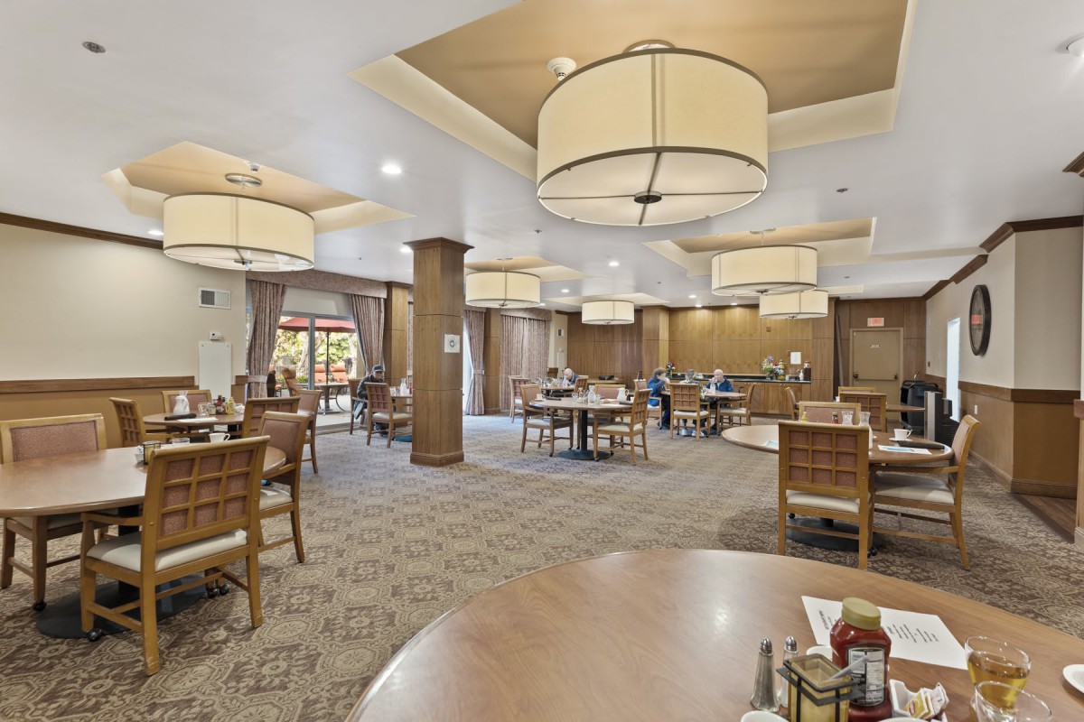 A spacious dining area with elegant lighting and comfortable seating.