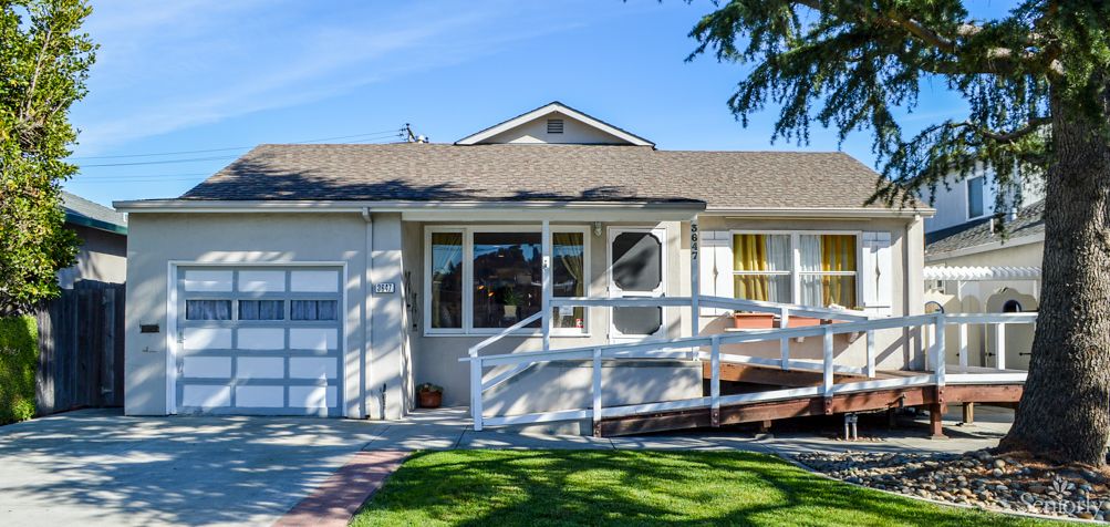 A cozy suburban house with a front ramp and well-maintained lawn.