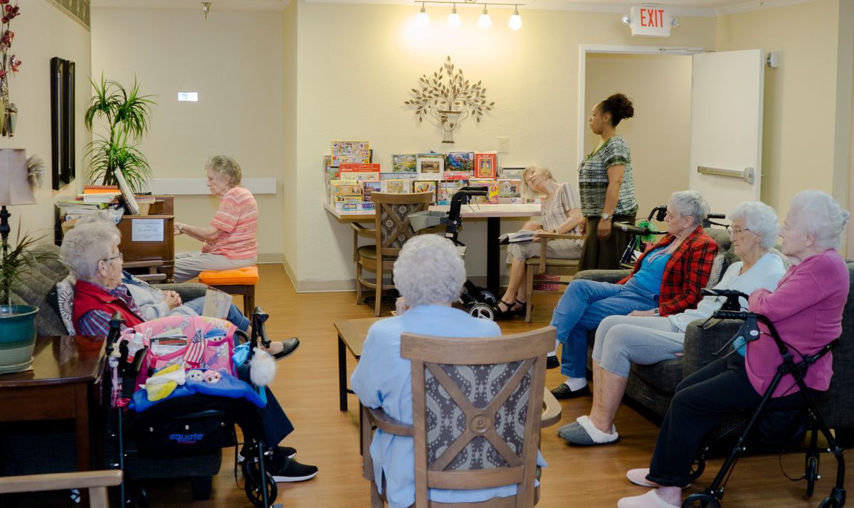 A group of elderly individuals participating in an activity at a care home.