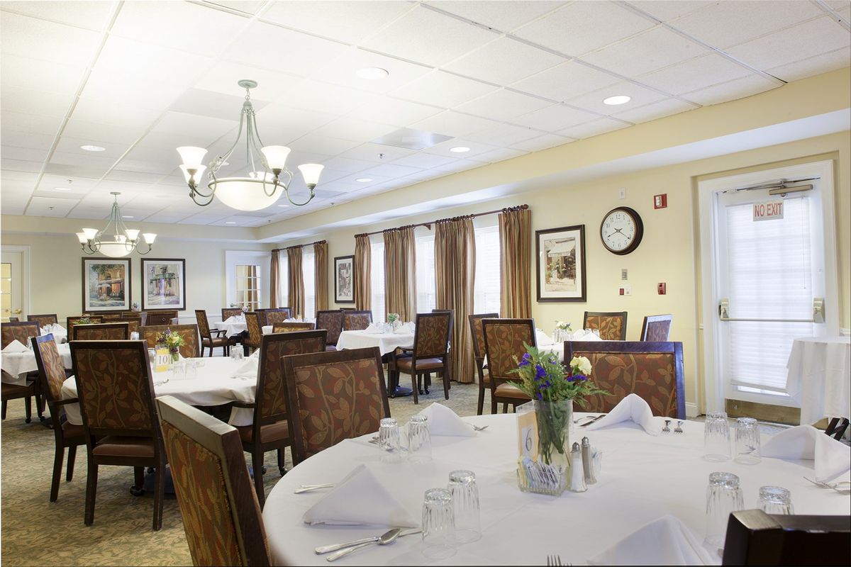 A well-appointed dining room with elegantly set tables and warm lighting.