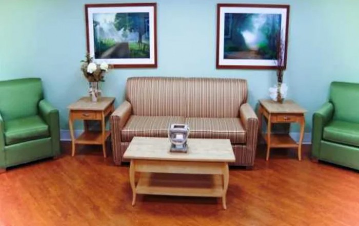 A cozy living room with a striped sofa, wooden coffee table, and side tables adorned with decorative items.