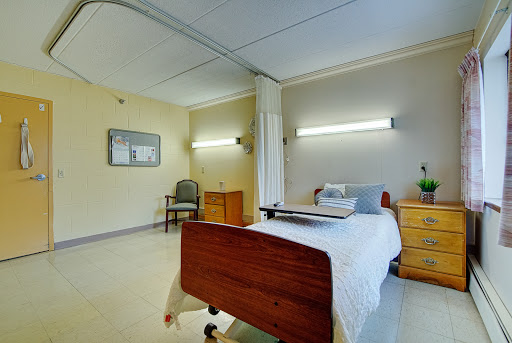 A well-lit hospital room featuring a bed and essential furnishings.