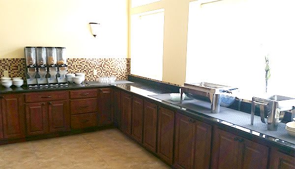 A modern kitchen featuring dark wooden cabinets and a sleek black countertop.
