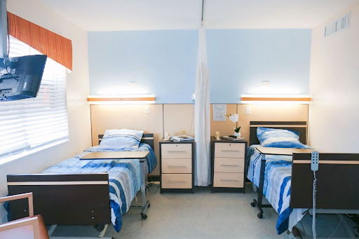 A shared patient room featuring two beds, designed for comfort and care.