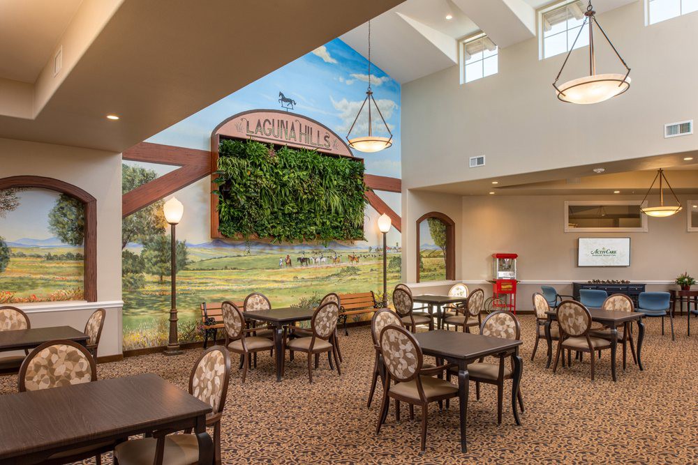 A well-lit dining area with elegant decor, featuring a large mural and skylights.