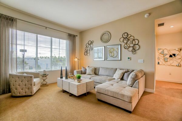 A modern living room with a comfortable couch, stylish wall art, and large windows.