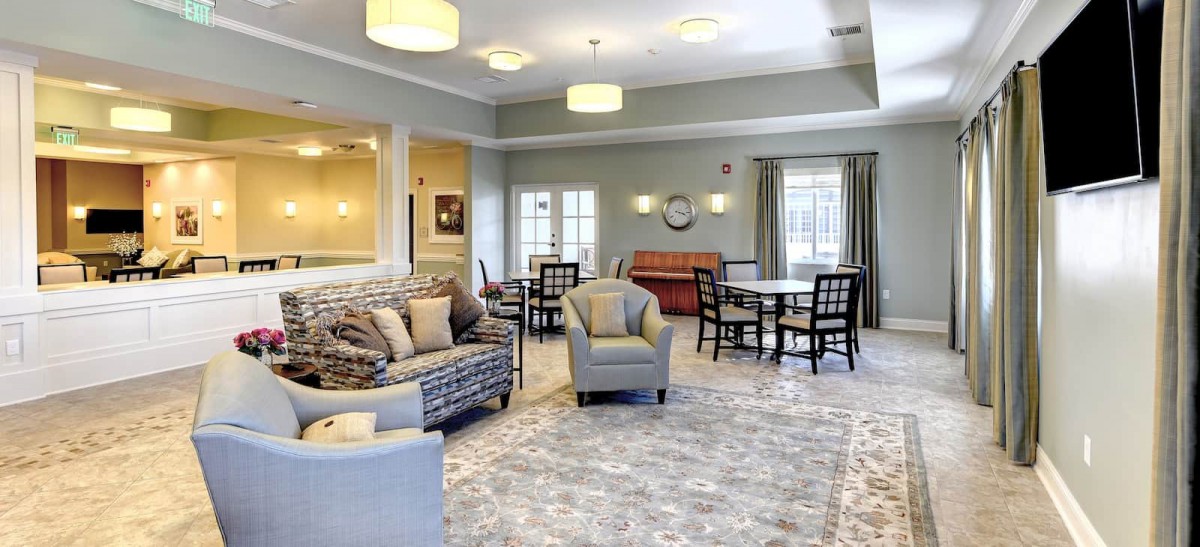 A spacious and elegantly decorated living room with comfortable seating and soft lighting.