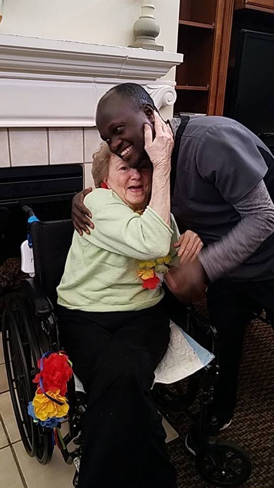 A heartwarming moment between two people, one in a wheelchair, embracing with smiles.