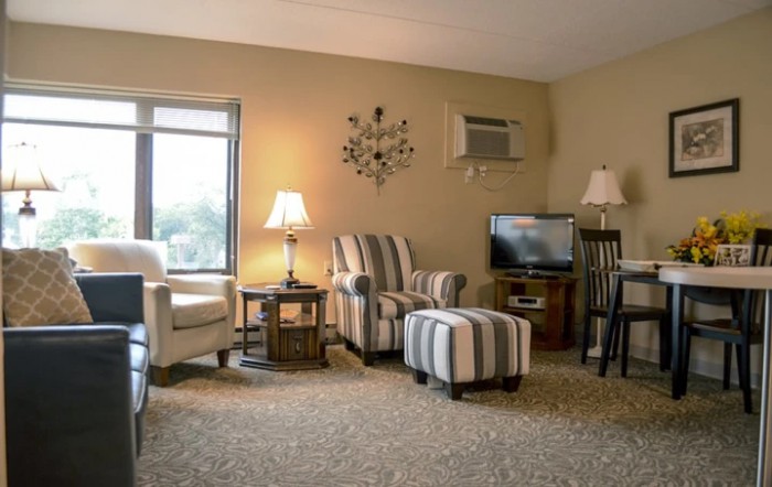 A cozy living room with striped furniture and warm lighting.