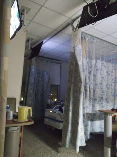 A view of a patient room in a hospital with curtains separating different areas.