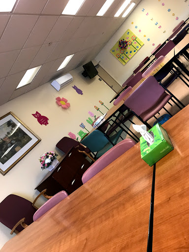 A cozy community space with tables and chairs, decorated with colorful art.
