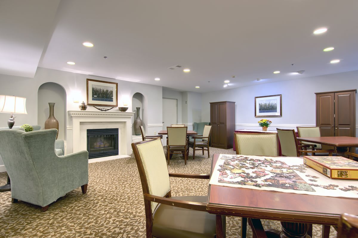 A cozy indoor room with seating areas, a fireplace, and decorative artwork.