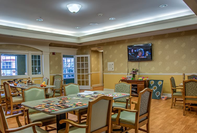A cozy dining area with a table, chairs, and a wall-mounted television.