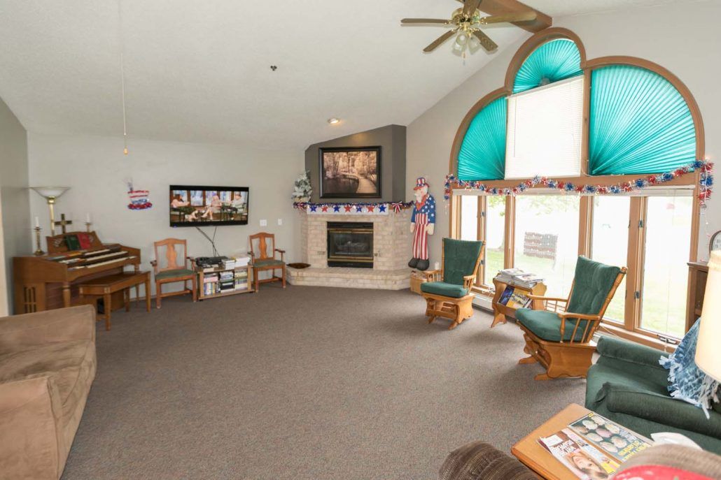A spacious living room featuring a fireplace, comfortable seating, and large windows providing natural light.