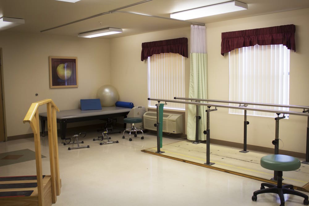 A physical therapy room equipped with parallel bars and exercise equipment.