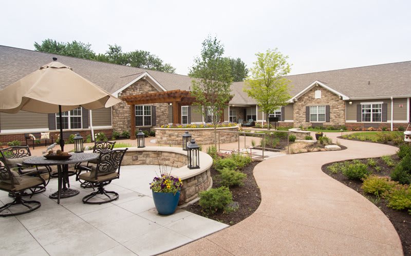 A beautifully landscaped garden with outdoor seating areas and a modern building in the background.