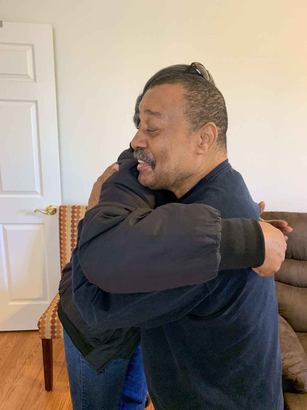 Two people sharing a warm embrace indoors.