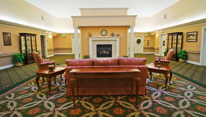 A cozy hotel lobby with a central fireplace and comfortable seating arrangement.