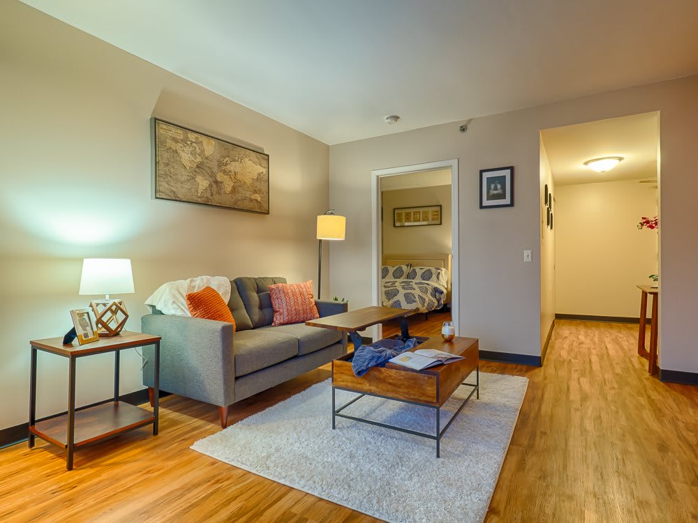 A cozy living room with a sofa, coffee table, and warm lighting.
