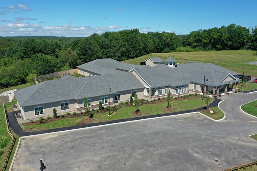 Aerial view of a large building surrounded by greenery and trees.
