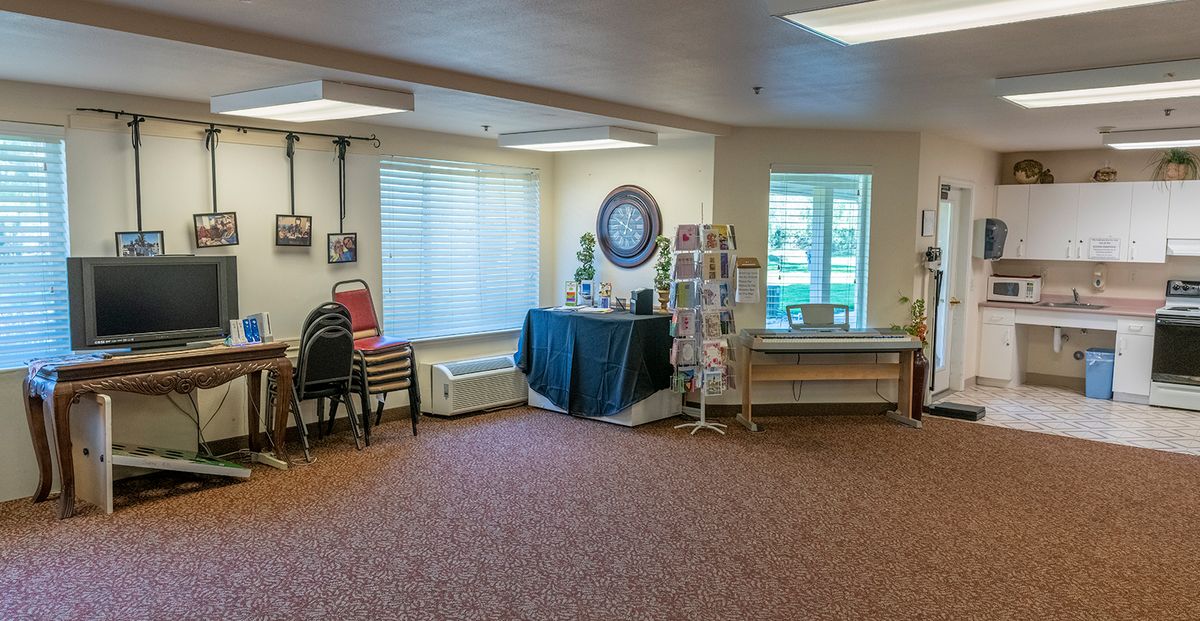 A cozy waiting room with chairs, a large wall clock, and a brochure stand.