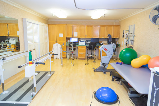 A well-equipped physical therapy room featuring various exercise machines and rehabilitation tools.