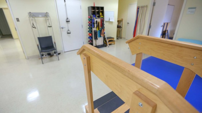 A physical therapy room equipped with exercise equipment and walking aids.
