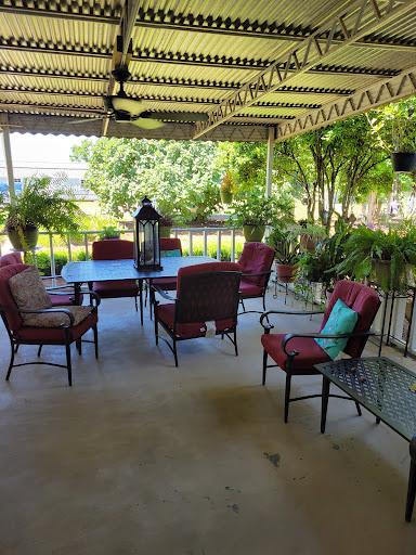 A serene outdoor patio setup with comfortable seating and lush greenery.