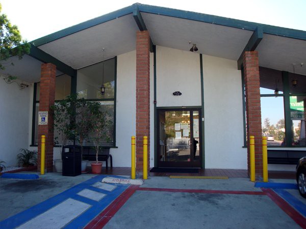 A building entrance with an accessible ramp and parking area.