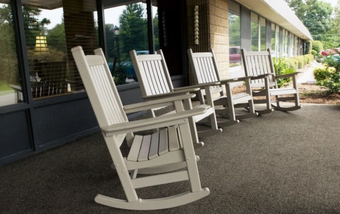 A row of wooden rocking chairs on an outdoor porch.