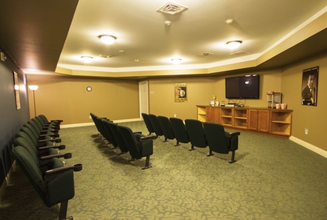 A home theater room with rows of seating facing a large screen for entertainment.