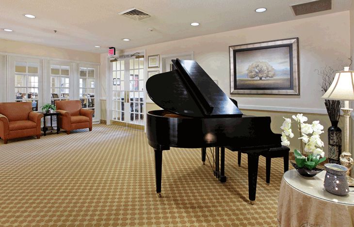 A cozy living room featuring a grand piano and comfortable seating.