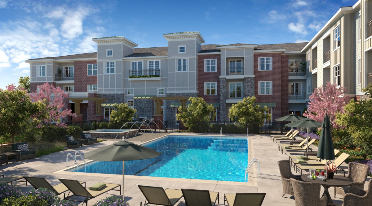 A modern apartment complex with a swimming pool and lounge area.