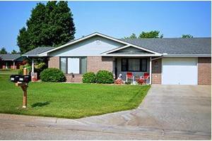 A suburban house with a well-maintained lawn and porch.