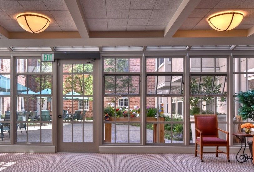 A cozy lobby area with glass doors and windows overlooking an outdoor patio.