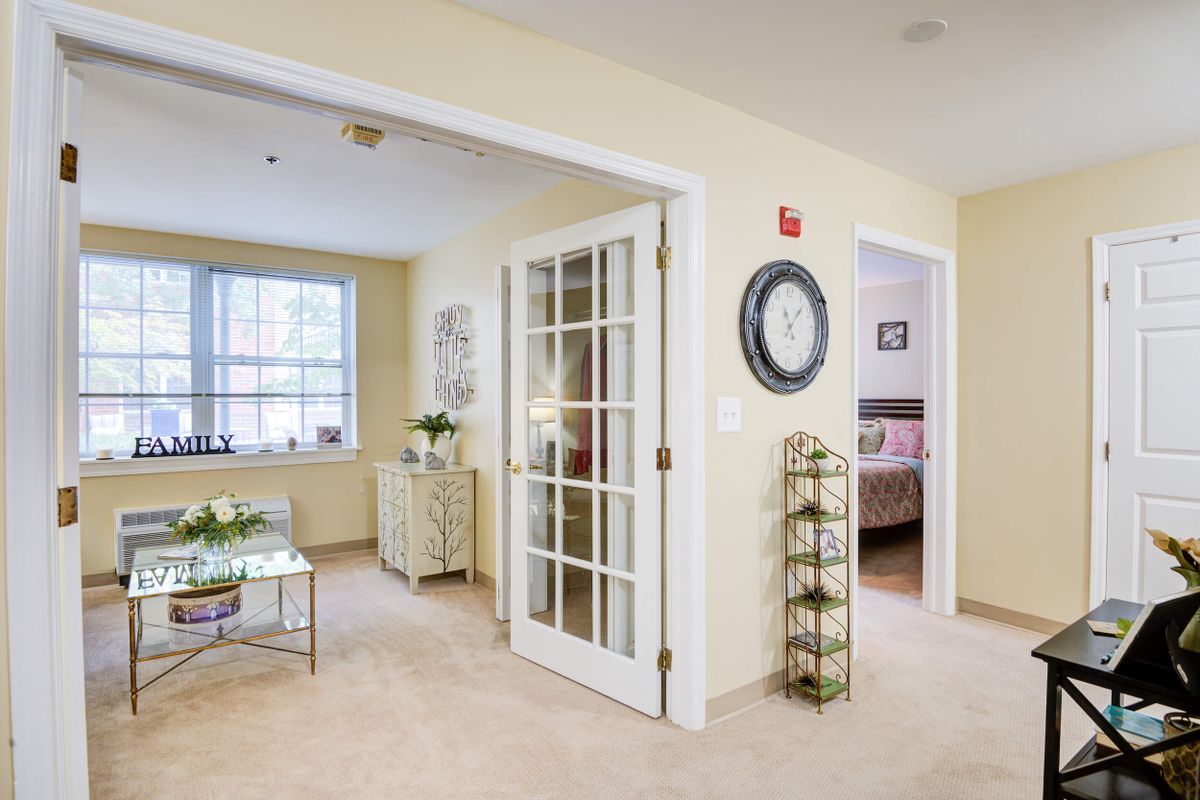 A cozy living room with a glass door, soft lighting, and elegant decor.