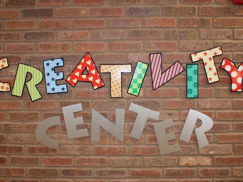 A colorful sign on a brick wall spelling 'Creativity Center'.
