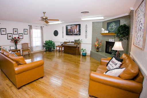 A spacious and inviting living room featuring warm wooden floors, comfortable seating, and a cozy fireplace.