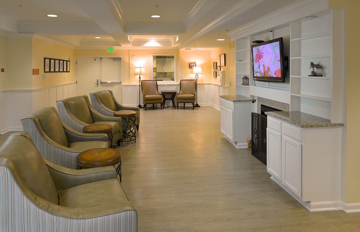 A modern living room with comfortable seating, ambient lighting, and a wall-mounted television.