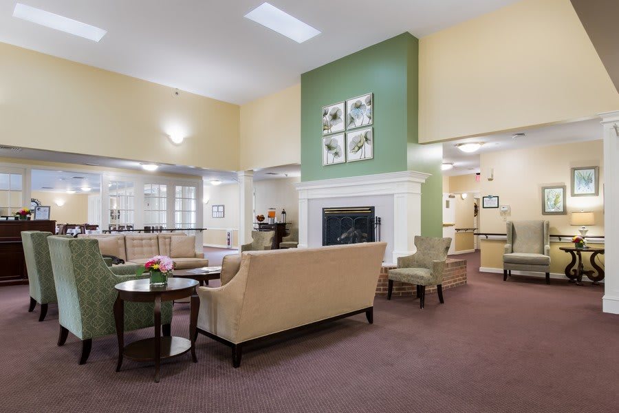A modern living room with comfortable seating and a central fireplace.