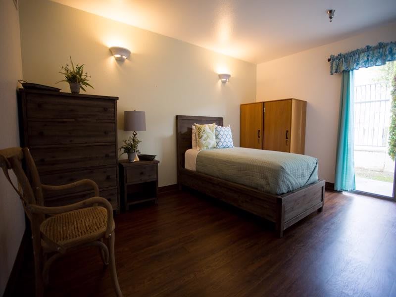 A cozy bedroom with a single bed and warm lighting.
